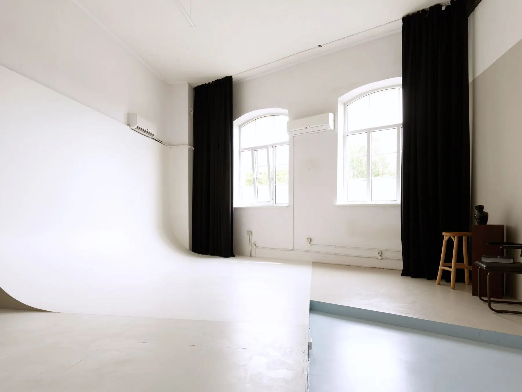 YASHA Photo Studio — Fashion zāle: baltā ciklorāma, arku logi un melni aptumšošanas aizkari